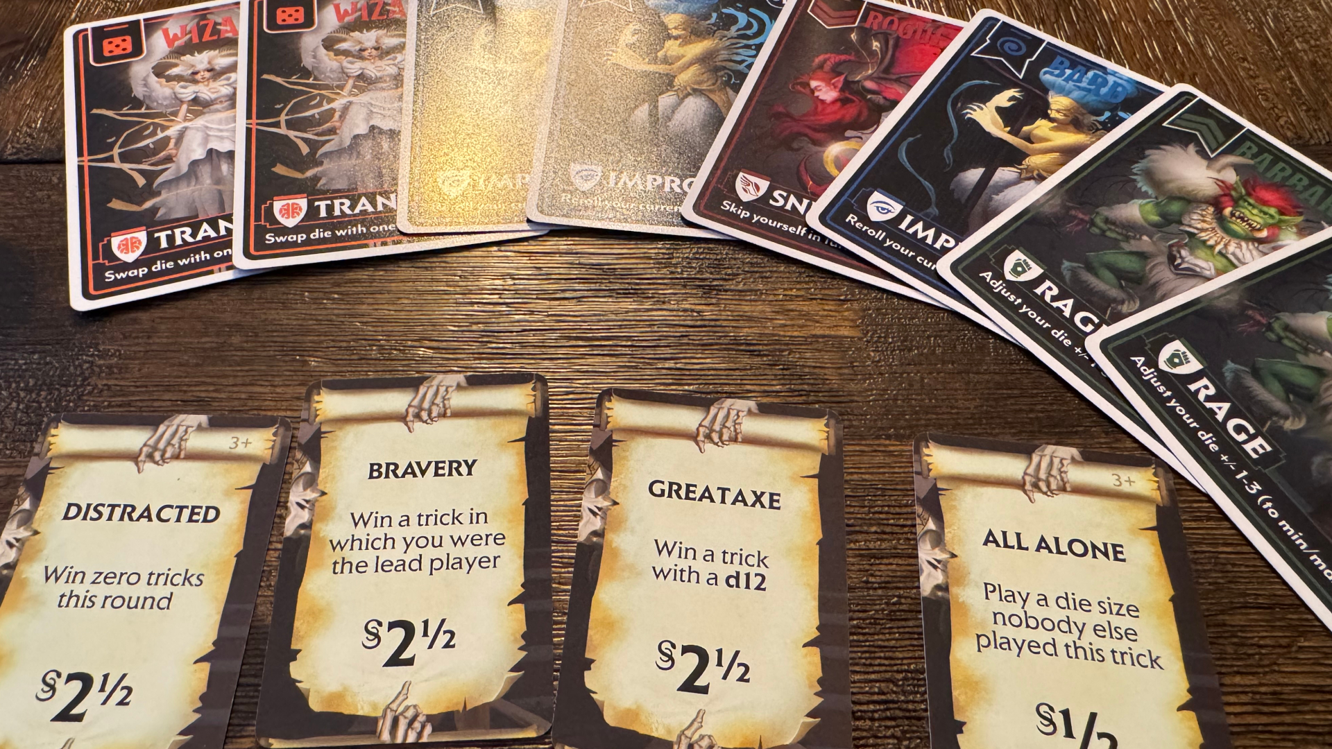 A series of cards with text and fantasy artwork laid out in rows on a wooden surface