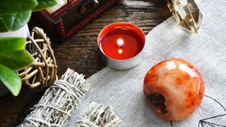 Red Carnelian crystal and lit candle in the kitchen showing how to use crystals in the home for protection