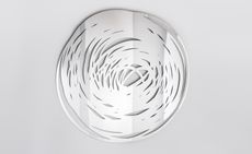 Scribble round mirror made of stainless steel and MDF hanging on a white wall