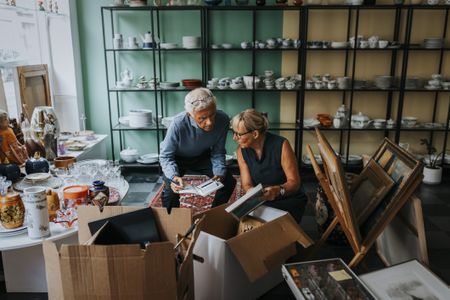 Male and female colleagues discussing while sitting in antique shop