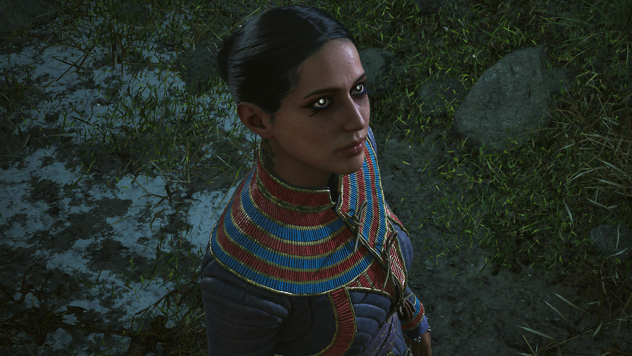 The Blood of Dawnwalker - Lacra, a woman with piercing white pupils and tightly pulled back, black hair standing outside in the dark