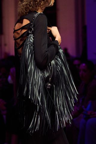 close up shot of black Versace fringe bag on runway