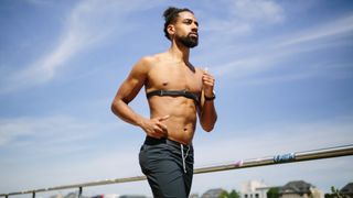 Man running wearing chest strap heart rate monitor