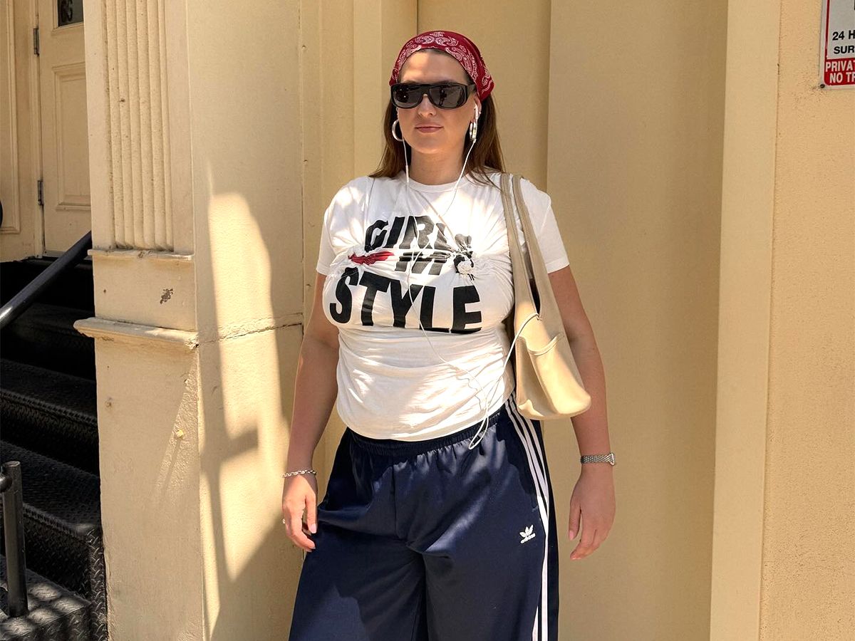 Influencer Raeann Langas wears Adidas track pants with a graphic tee and black sunglasses.