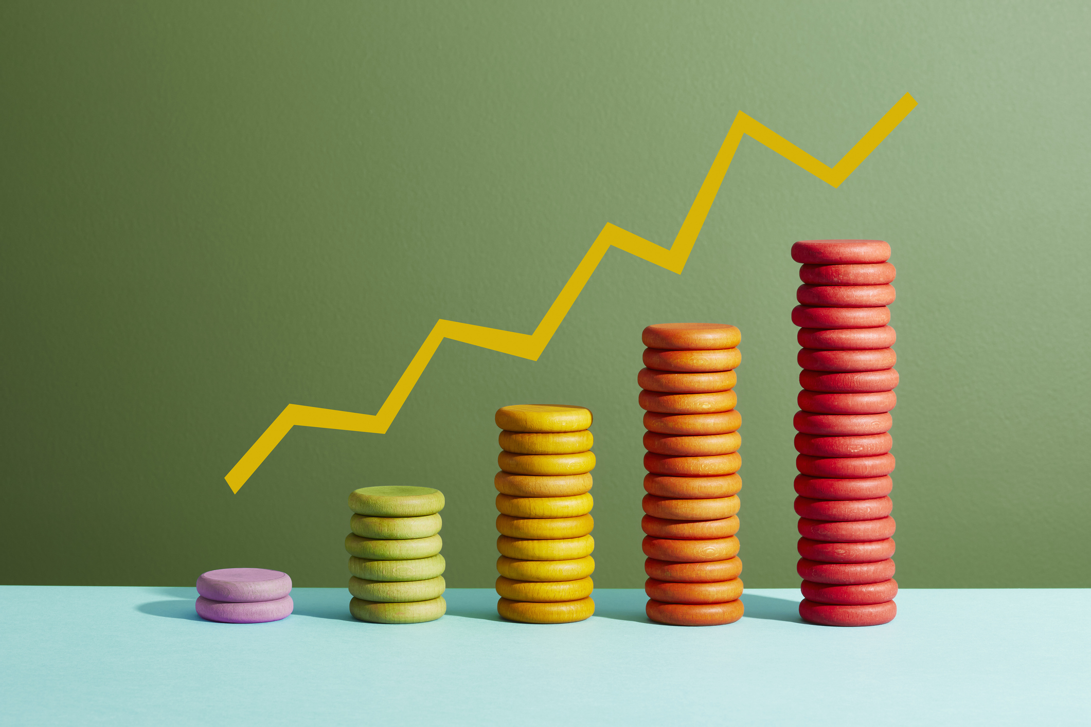 stacks of multi-colored discs with a yellow trendline above them to signal inflation