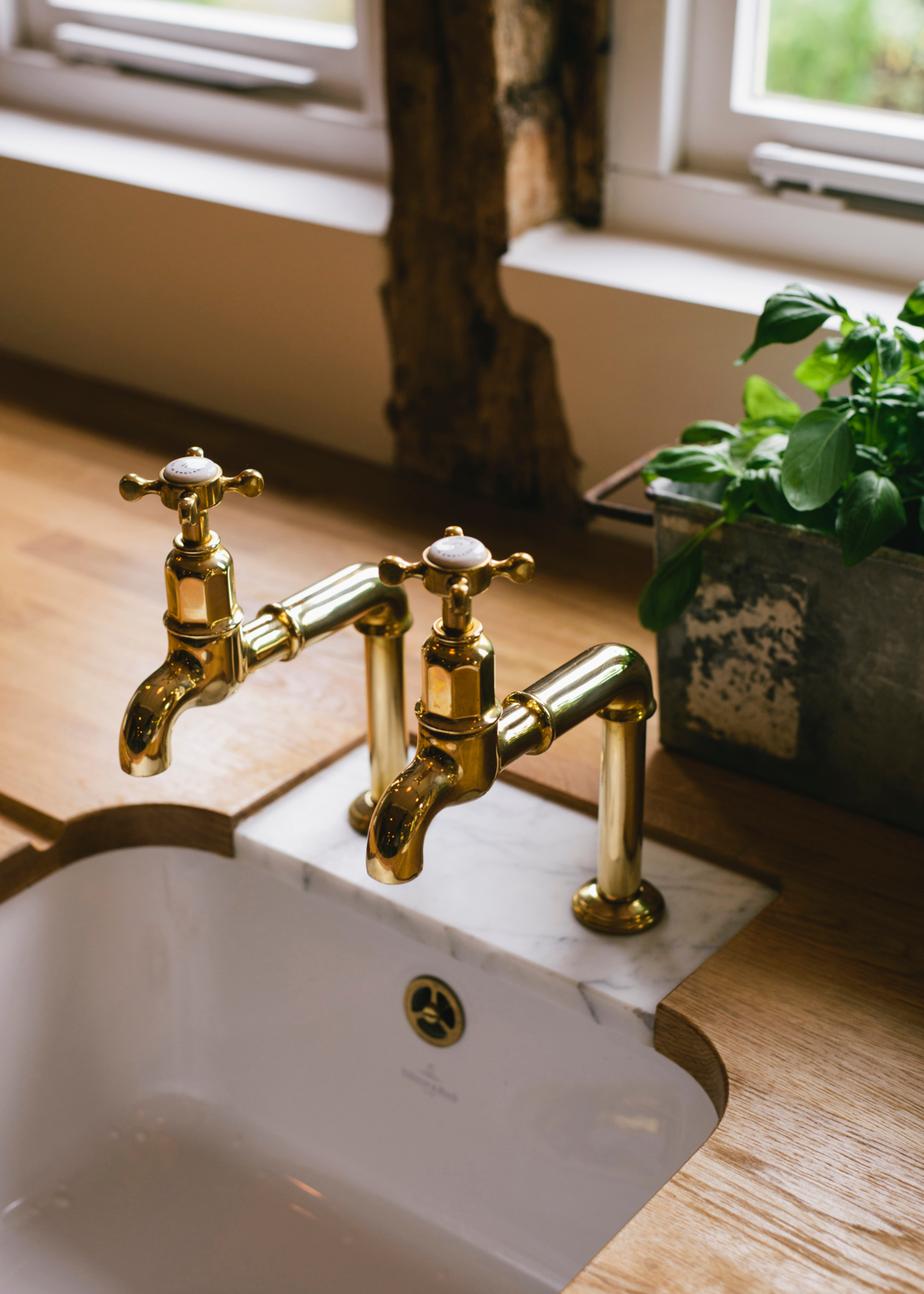 a small marble insert around gold taps in a wooden countertop