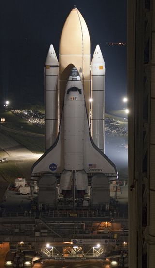 Space shuttle Discovery makes the nighttime move to launch pad 39A from the Vehicle Assembly Building.