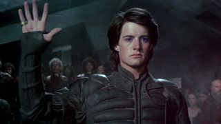 Kyle MacLachlan as Paul Atreides with his hand up