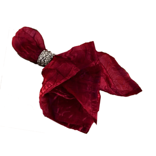 A burgundy napkin with a silver ring around it