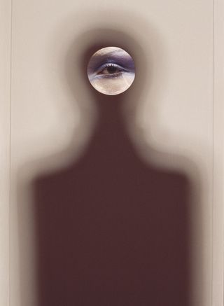 Guy Bourdin photograph of made-up eye looking through hole