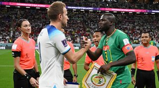 Harry Kane of England and Kalidou Koulibaly of Senegal pose for a photo with match officials prior to the FIFA World Cup Qatar 2022 Round of 16 match between England and Senegal at Al Bayt Stadium on December 04, 2022 in Al Khor, Qatar.