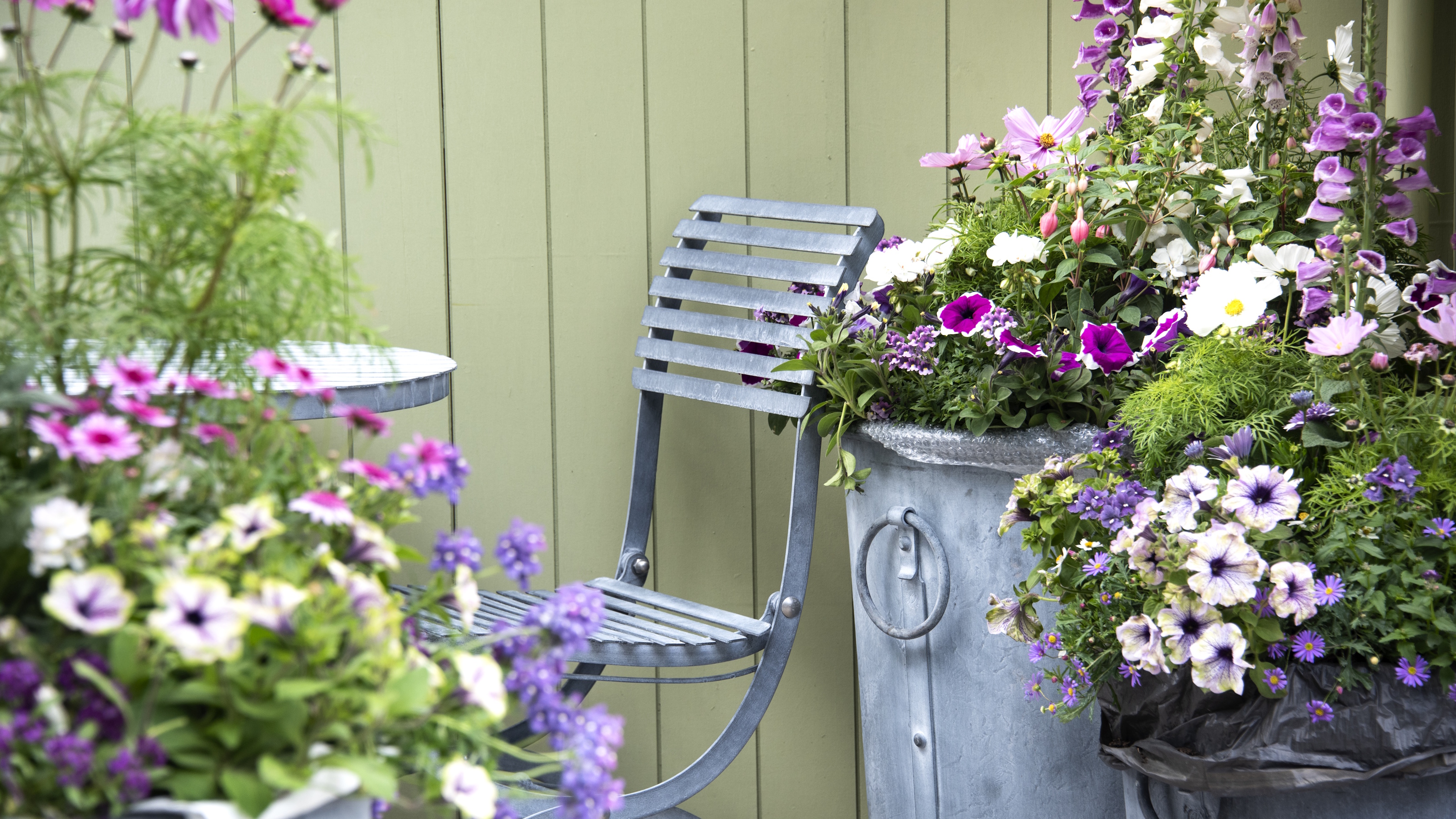 Seating area surrounded by planters in bloom