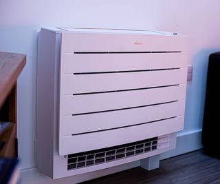 white Daikin Multi+ unit which looks like a modern radiator or space heater on wall in house