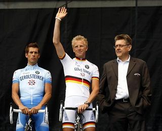 Gerolsteiner's Fabian Wegmann waves at the Tour de France as Hans-Michael Holczer (r) looks on and for future sponsorship