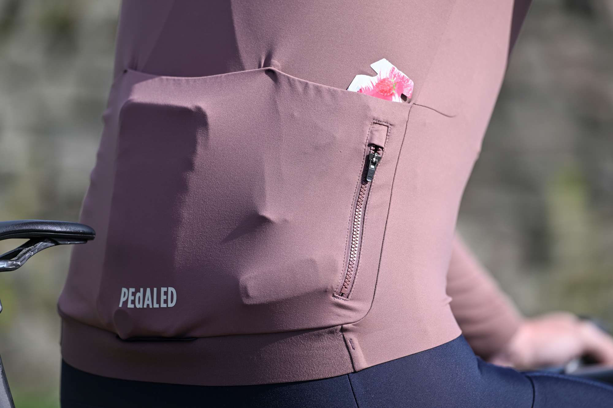 Close up of the rear pockets on a purple long-sleeved cycling jersey