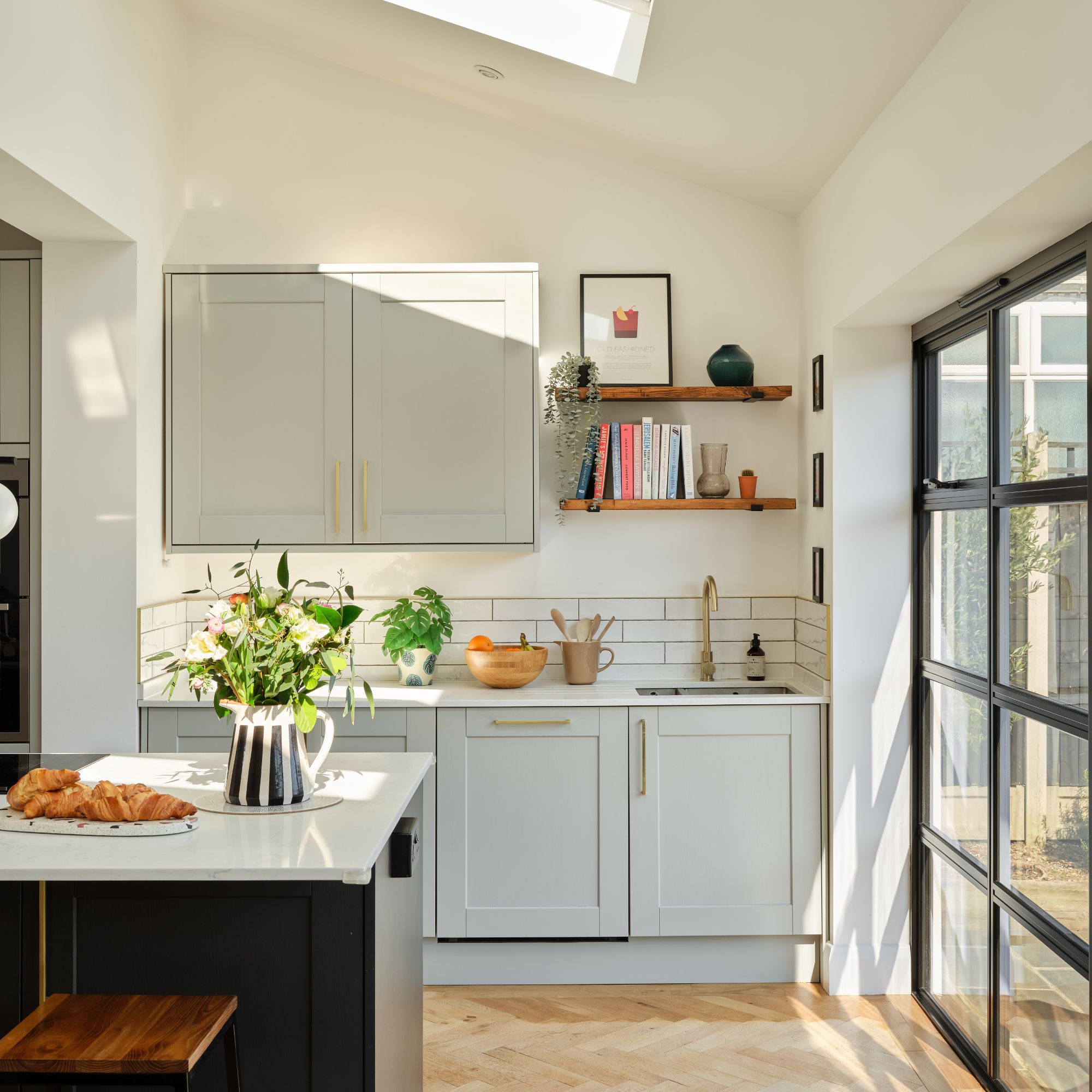 White painted kitchen with grey cupboards and an island in the middle