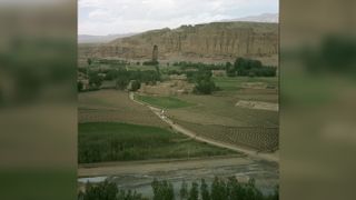 The Bamiyan Valley can be seen here with the Colossus of Buddha in the background, highlighting the immense size of the statue.