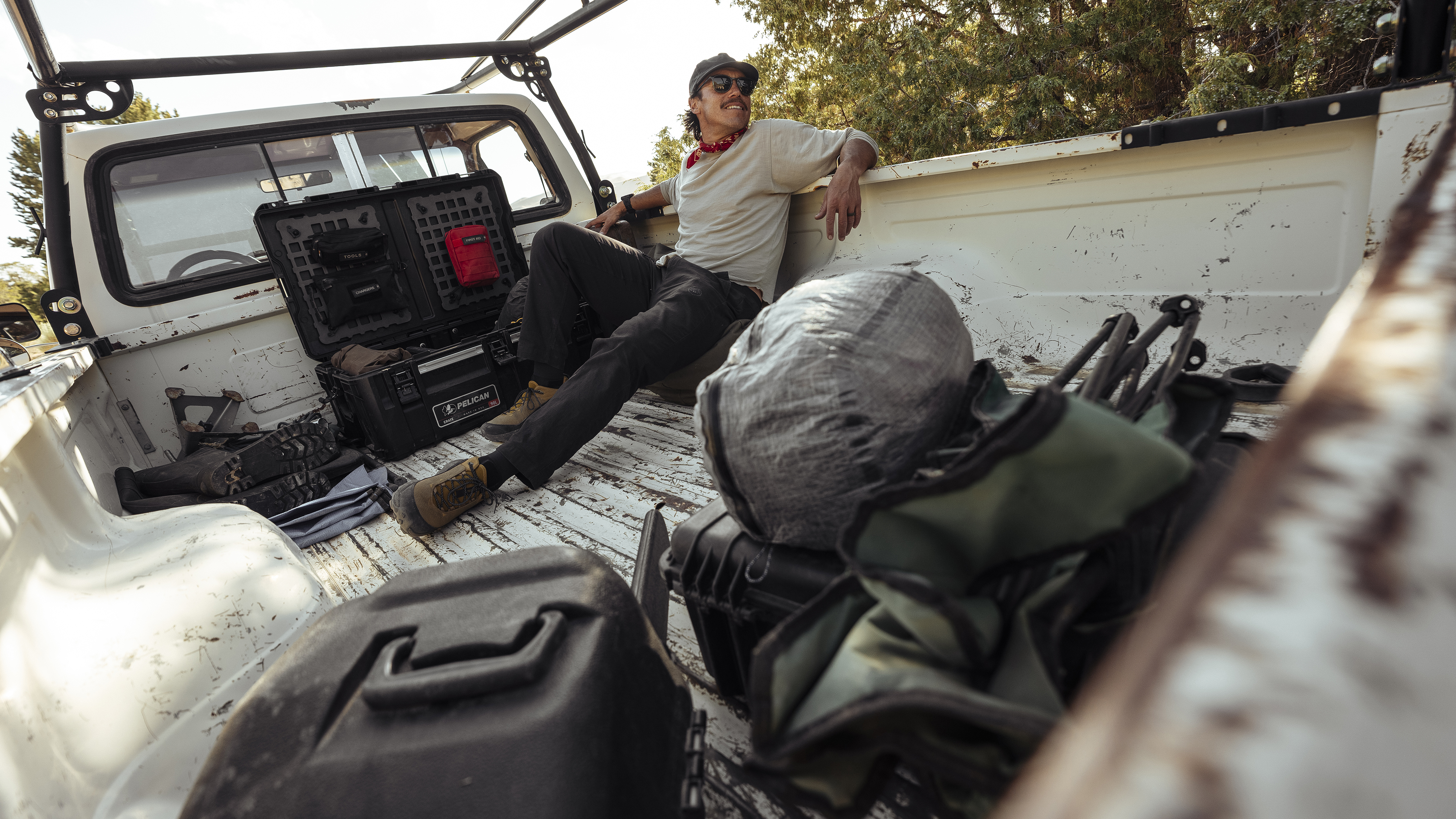 Photographer Chris Burkard in the back of a pickup truck with Pelican camera bags
