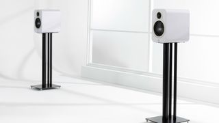 Q Acoustics 3020c speakers in white finish on stands in a minimalist room