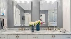Gray bathroom with marble double sink vanity and mirrors