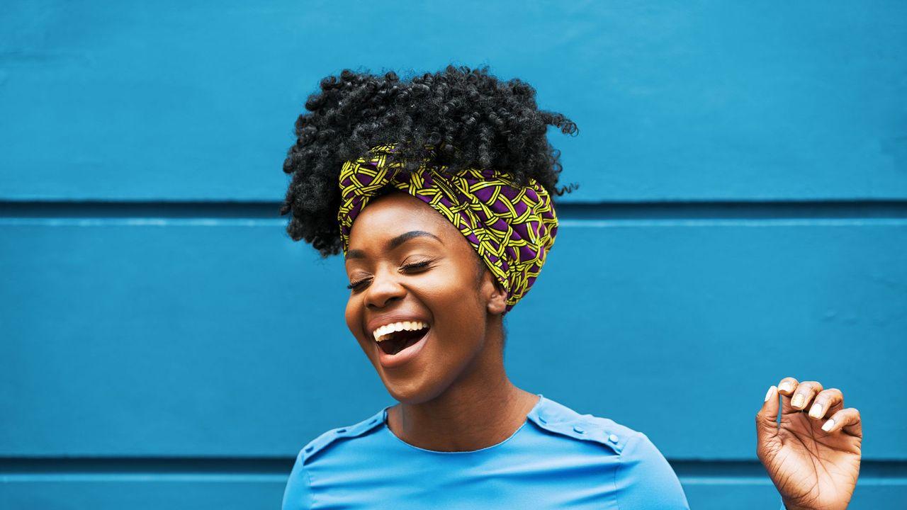 joyous woman infront of wall