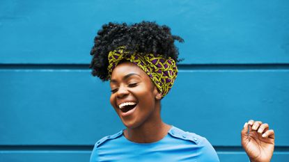 joyous woman infront of wall