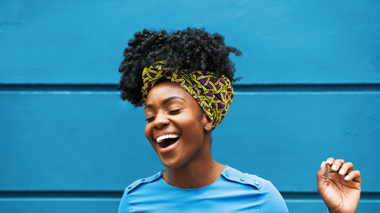 joyous woman infront of wall