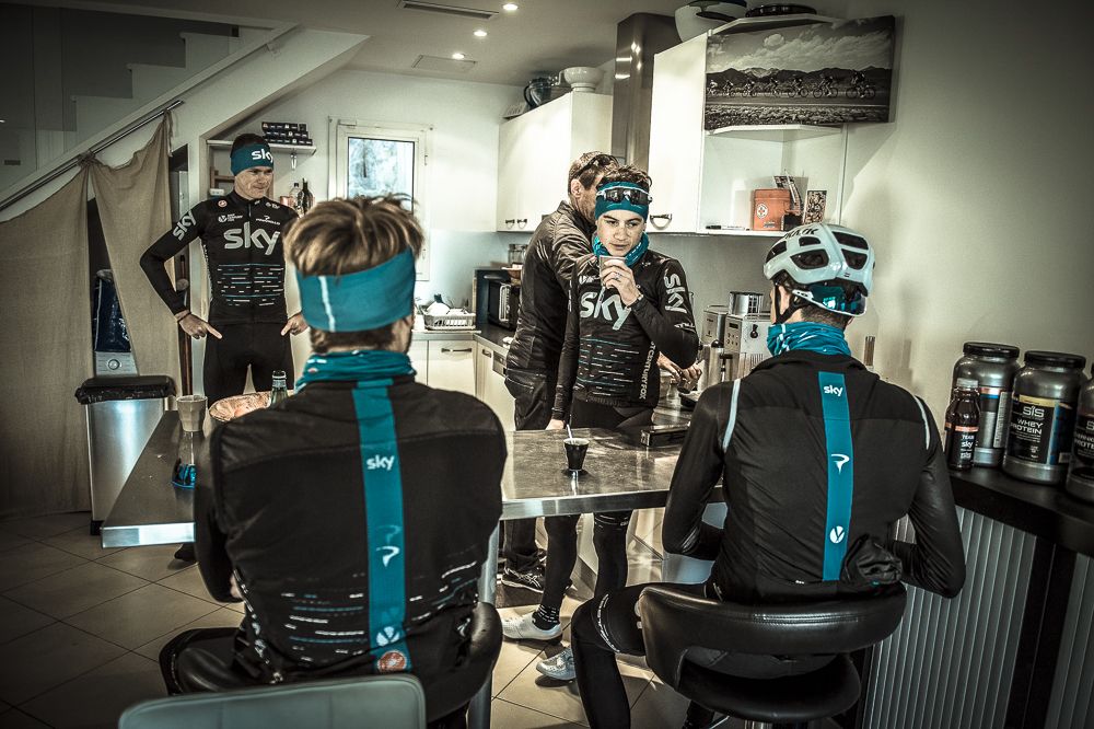 Kenny Elissonde sips his cappuccino with Tim Kerrison in the background making the coffee