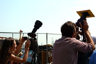 Photographers shooting the eclipse with DSLR cameras and solar filters attached