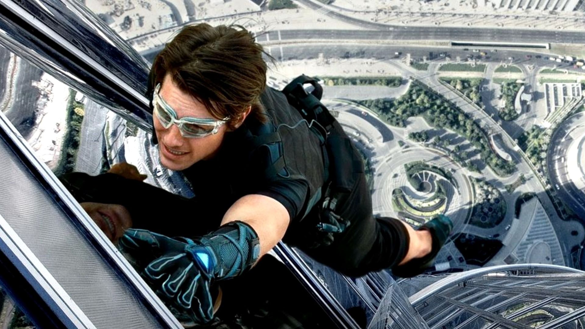Tom Cruise wears eye goggles and climbing gear while scaling the Burj Khalifa
