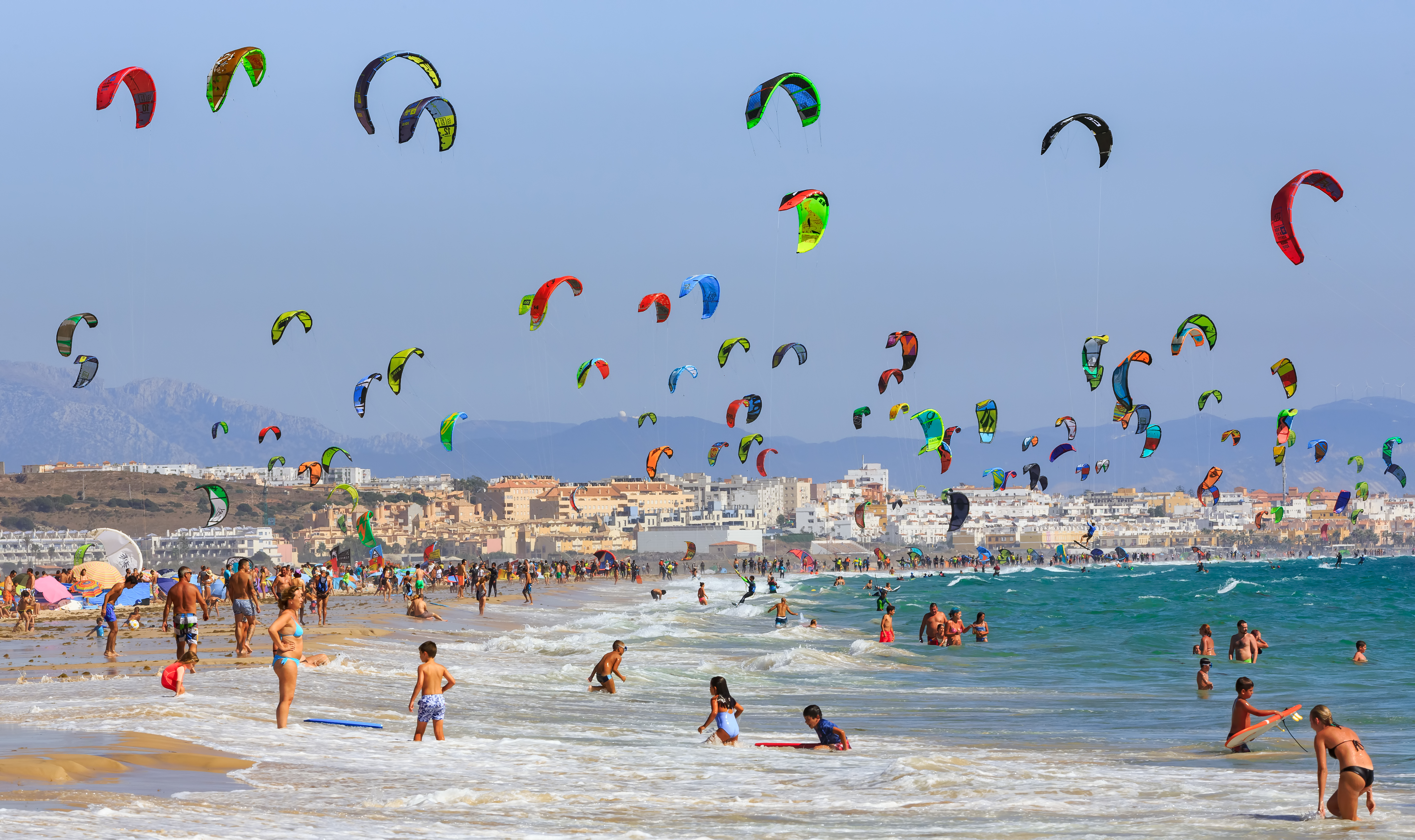 People fly kites at a beach in Tarifa, Spain