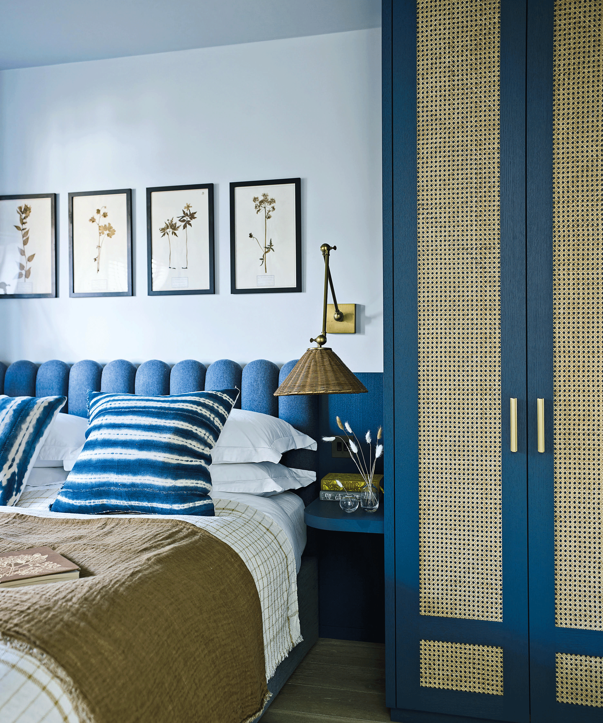 Bedroom with blue upholstered headboard with cane wardrobe