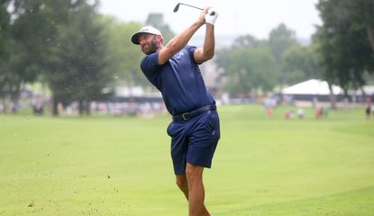 Dustin Johnson strikes a wedge shot and watches it in the air