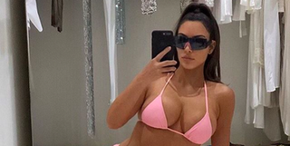 Kim Kardashian takes a selfie wearing a pink bikini.