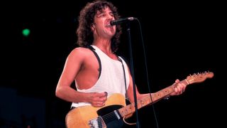 Billy Squier plays guitar as he performs onstage at the Poplar Creek Music Theater, Hoffman Estates, Illinois, September 2, 1984. 