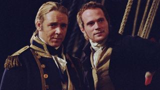 Russell Crowe and Paul Bettany standing together on their ship in Master and Commander.