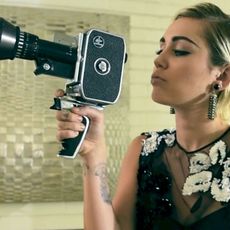 Miley Cyrus holding an old school video camera
