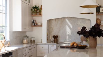 Image of a white kitchen with a plaster kitchen hood