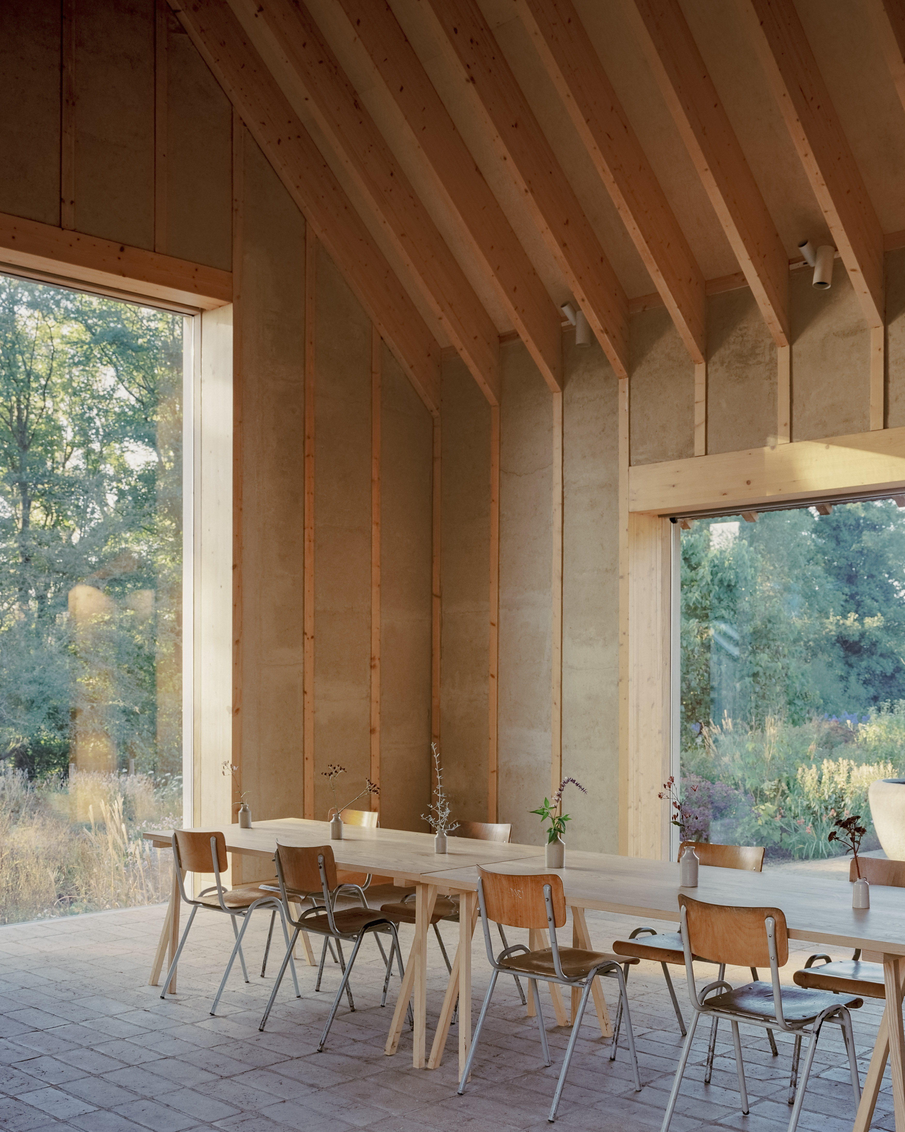 The Apple House, timber building with shingles and pitched roof set among wildflower fields