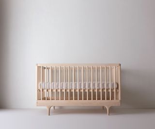 Infant's crib in wood with mattress in raised position