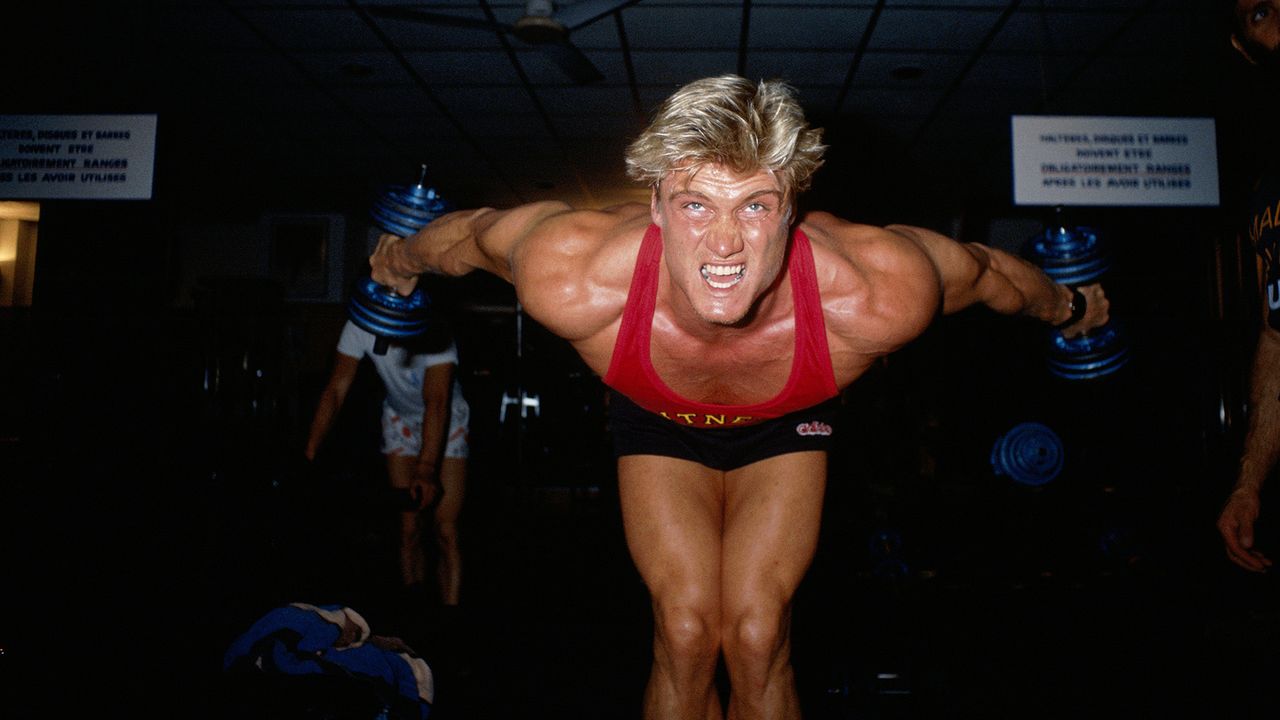 Dolph Lundgren working out with dumbbells in the 80s