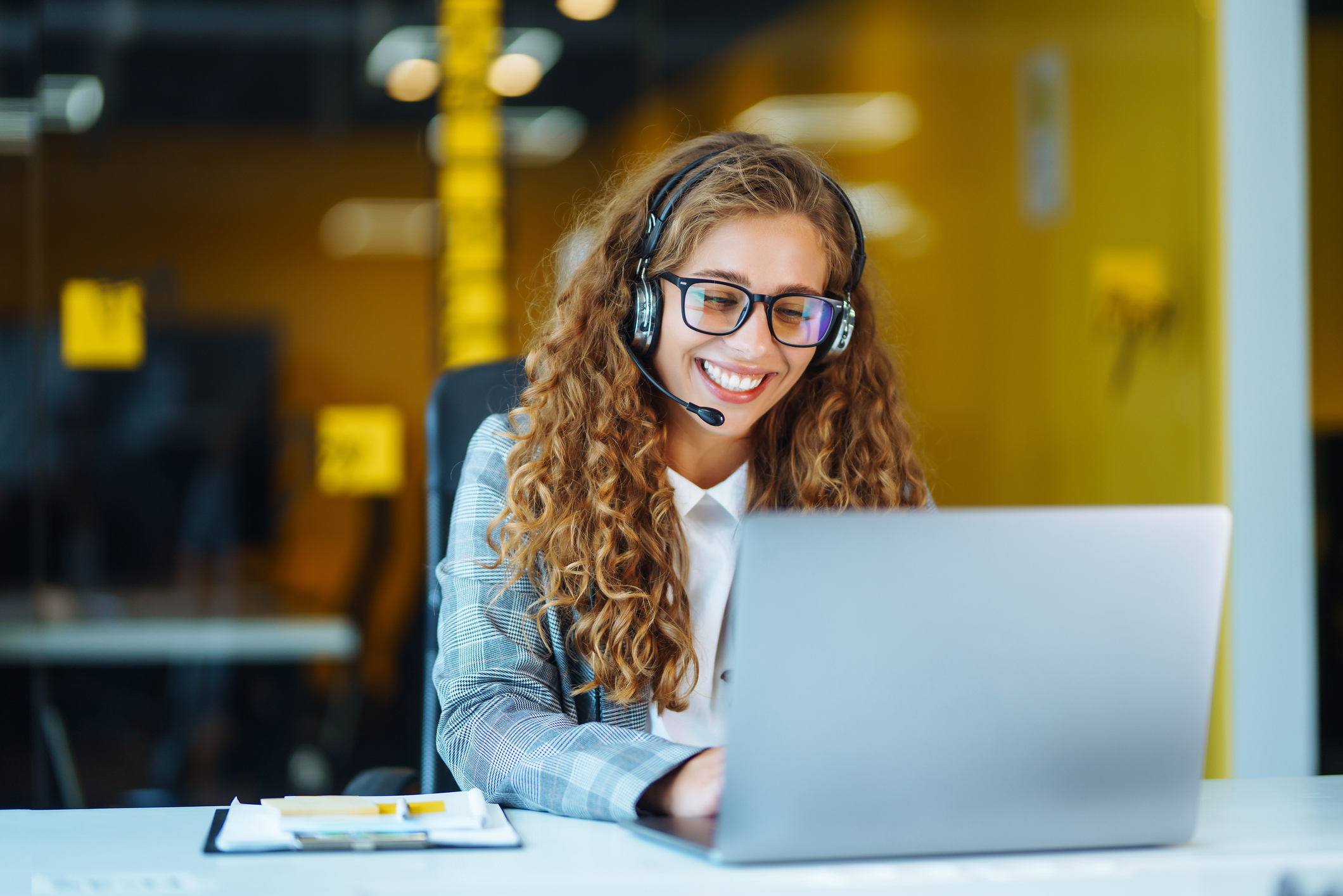 Call-Center-Agent mit Headset, der an der Support-Hotline im modernen Büro arbeitet Videokonferenz-Online-Schulung