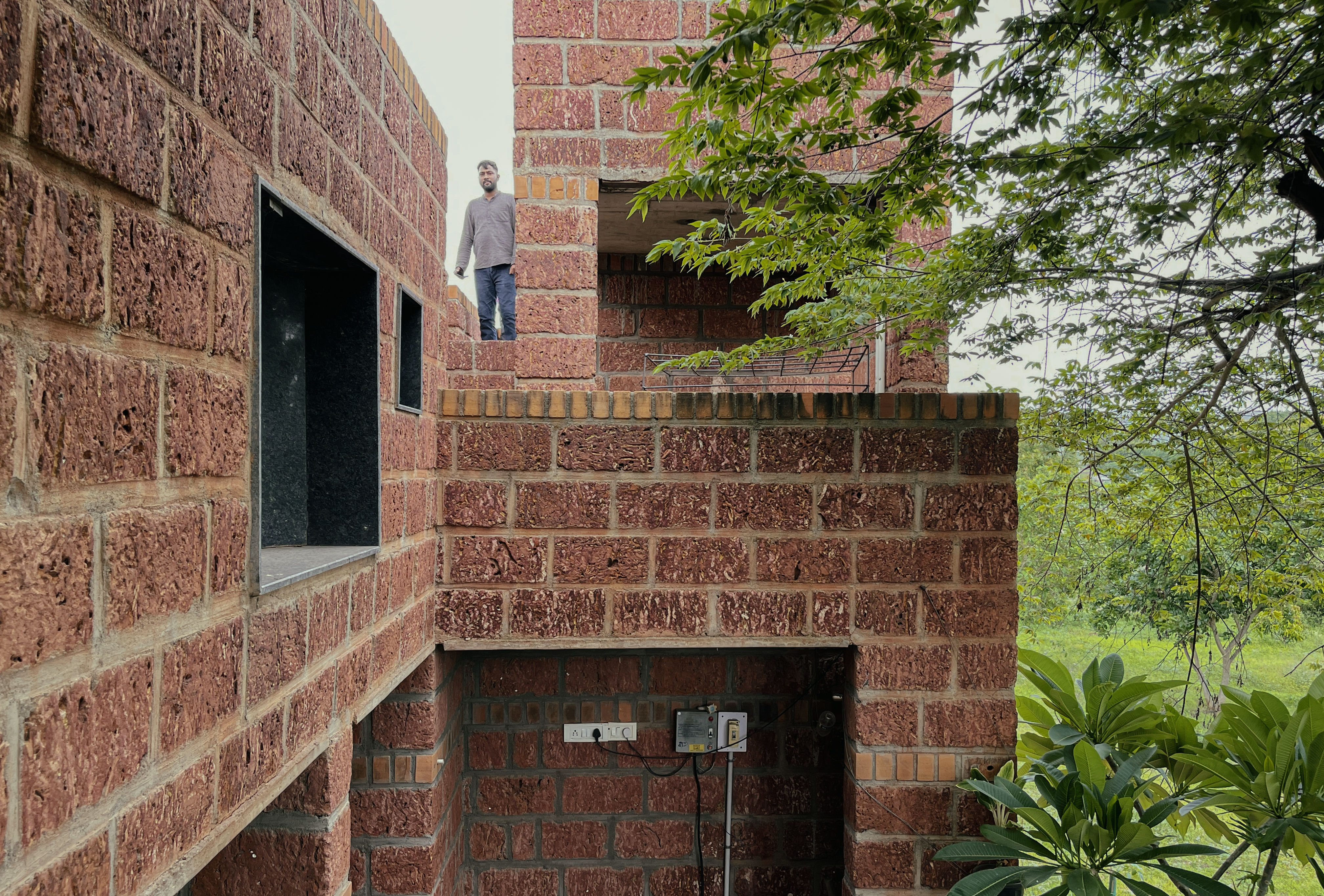 Kanade brothers house in India, brick structure in green surrounds