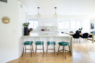 A white open plan living space with breakfast bar and dining area