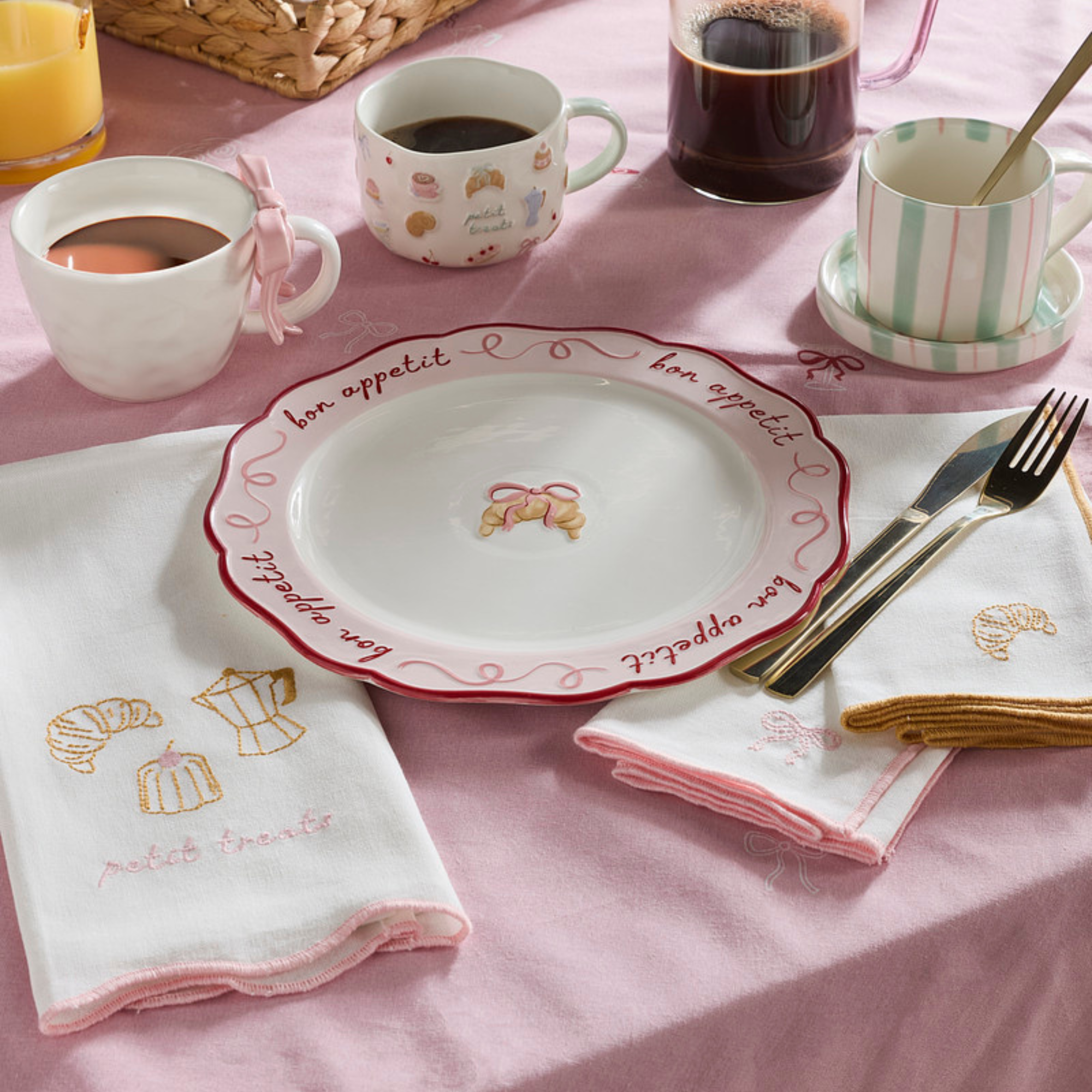 B&amp;amp;M croissant serving plate and napkins on a table with pink tablecloth.