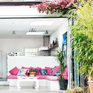 open kitchen with pink cushions and plants