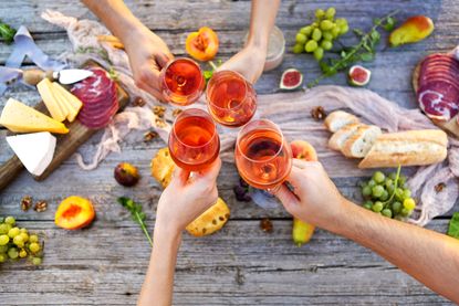 People toasting over a wooden table.