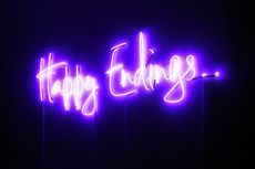 A glowing neon sign with the words "Happy Endings" in glowing letters.