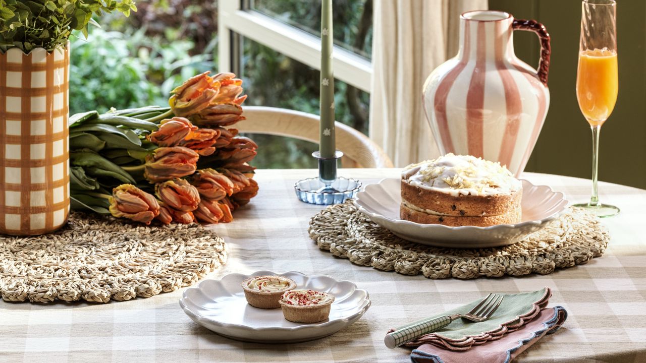 A dining table with a gingham tablecloth and flower plates