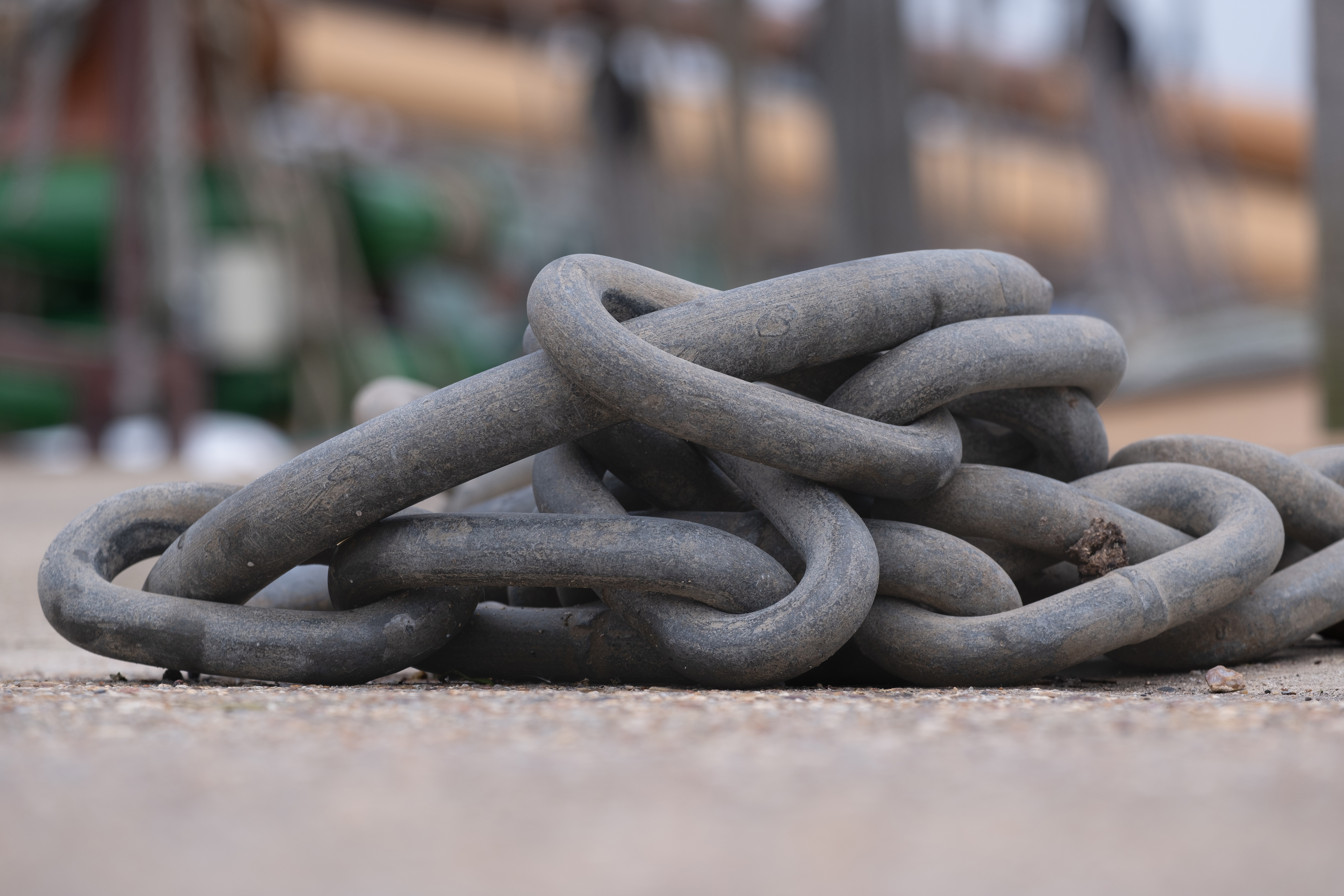 A large metal chain resting on the concrete ground